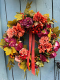 Coral Autumn Wreath — coral hydrangea, rosehips and golden maple leaves with a coral ribbon