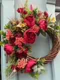 Crimson Peony Wreath — ruby peonies and coral berries on bare willow, hung on a pale blue door